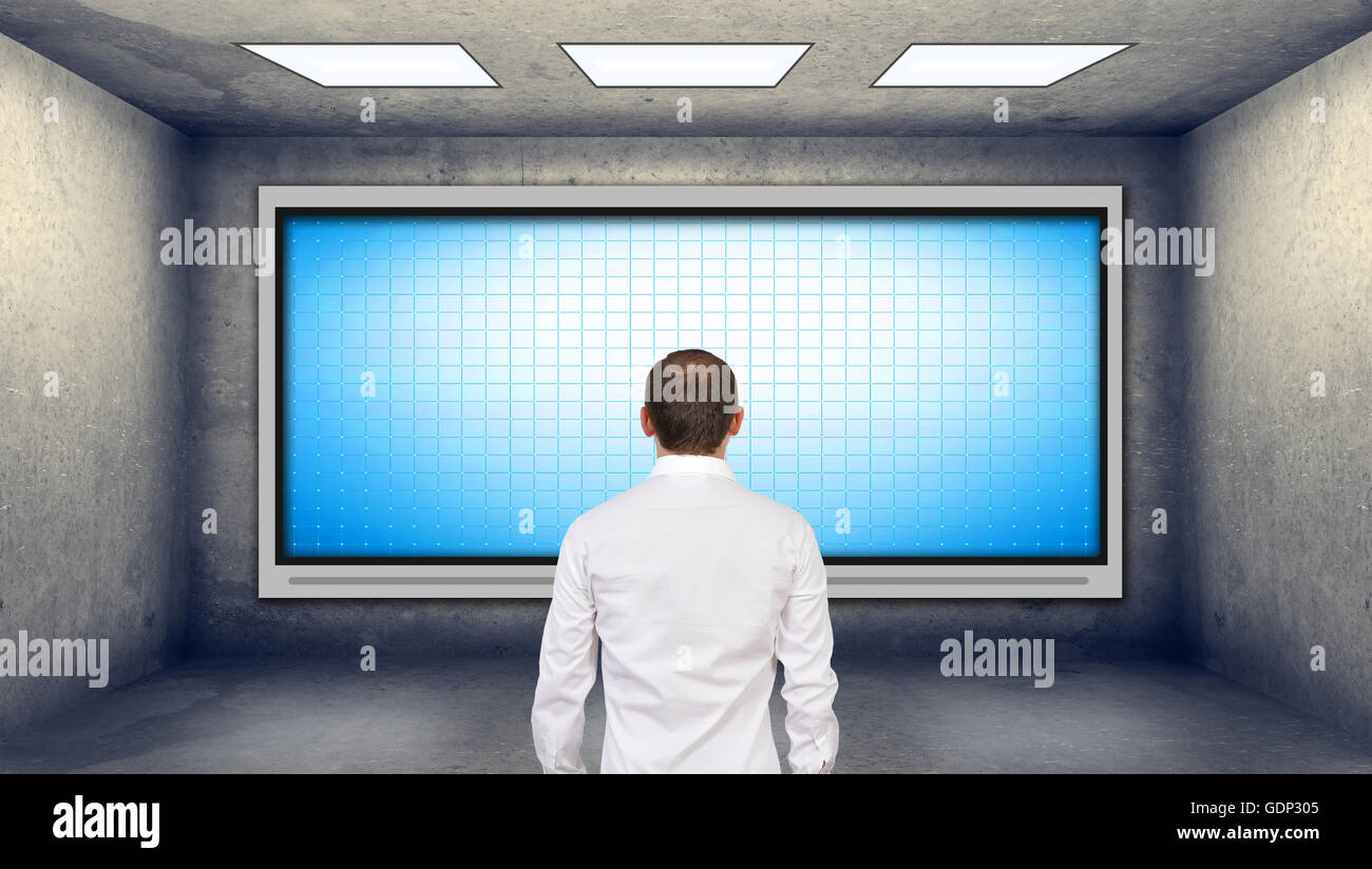 businessman looking at blank plasma tv on the wall in boardroom Stock Photo