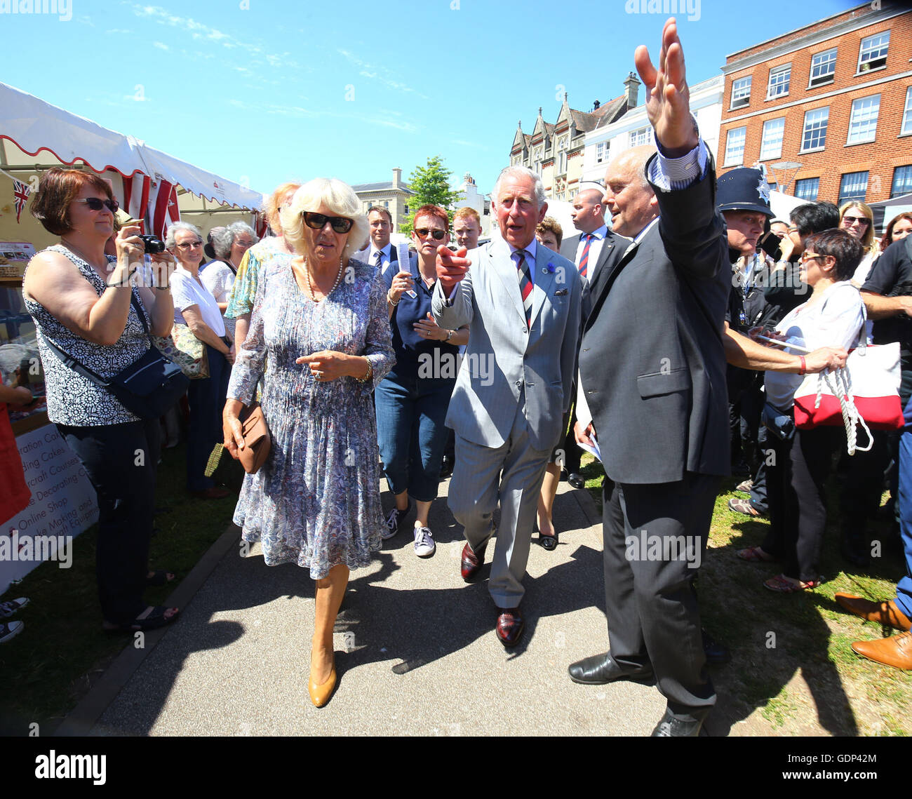 The Prince of Wales and Duchess of Cornwall are shown the way as they tour the Taste of the West's 25th anniversary Food Fair in the grounds of Exeter Cathedral on the second day of their annual visit to the South West. Stock Photo