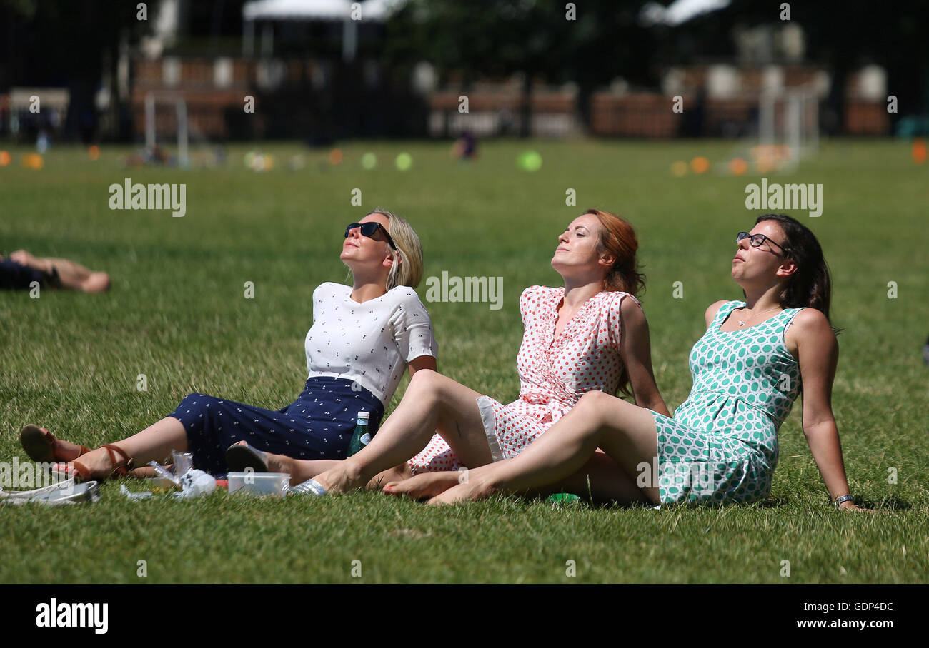 (Left to right) Becky Starr, Cesca Hall and Rachel de Minckwitz enjoy their lunch hour in Holland park, London, as Britain has sweltered on the hottest day of the year so far, with soaring temperatures sparking a surge in calls for medical help and causing delays on the railway. Stock Photo