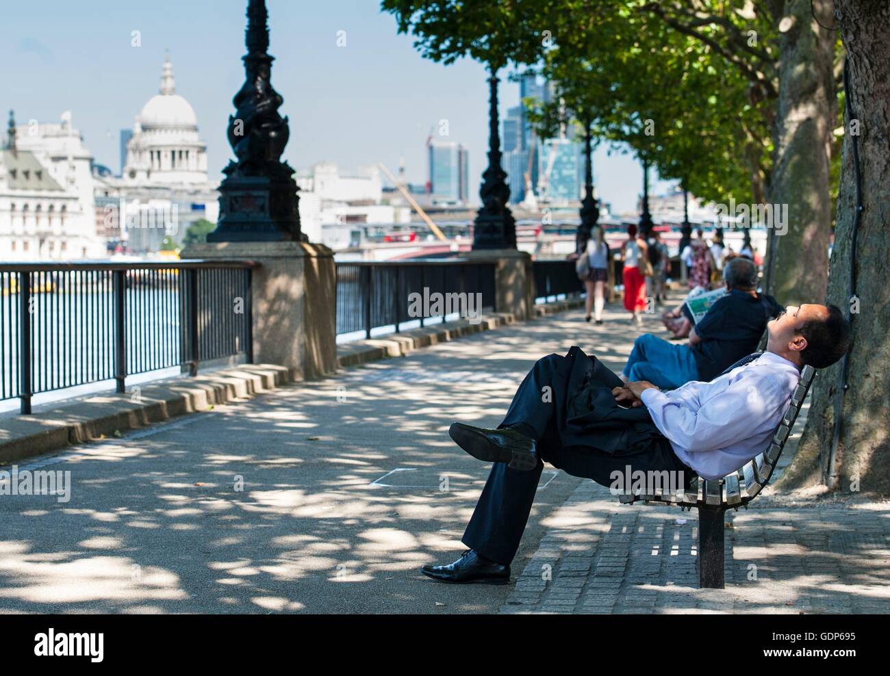 A man enjoys the hot weather along the Southbank in London, as Britain has sweltered on the hottest day of the year so far, with soaring temperatures sparking a surge in calls for medical help and causing delays on the railway. Stock Photo