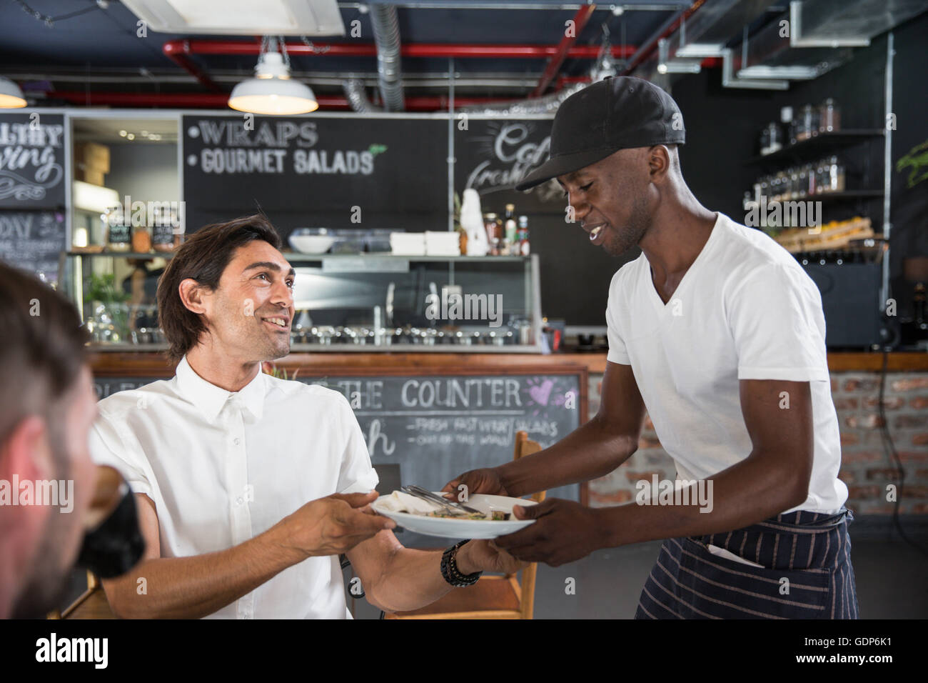 Waiter working in restaurant cleaning table for customer Stock Photo