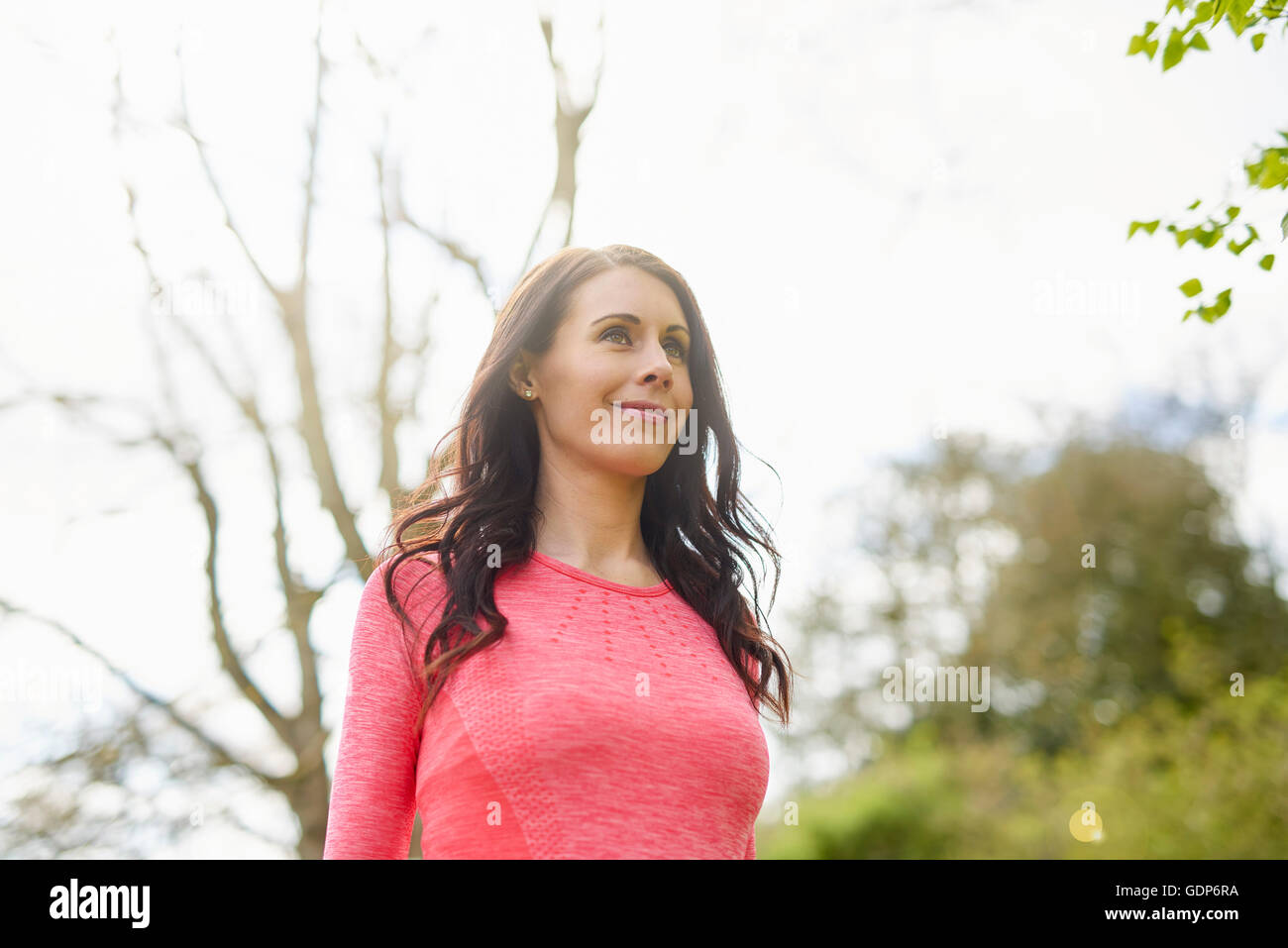 Mid adult woman walking in rural environment, low angle view Stock Photo