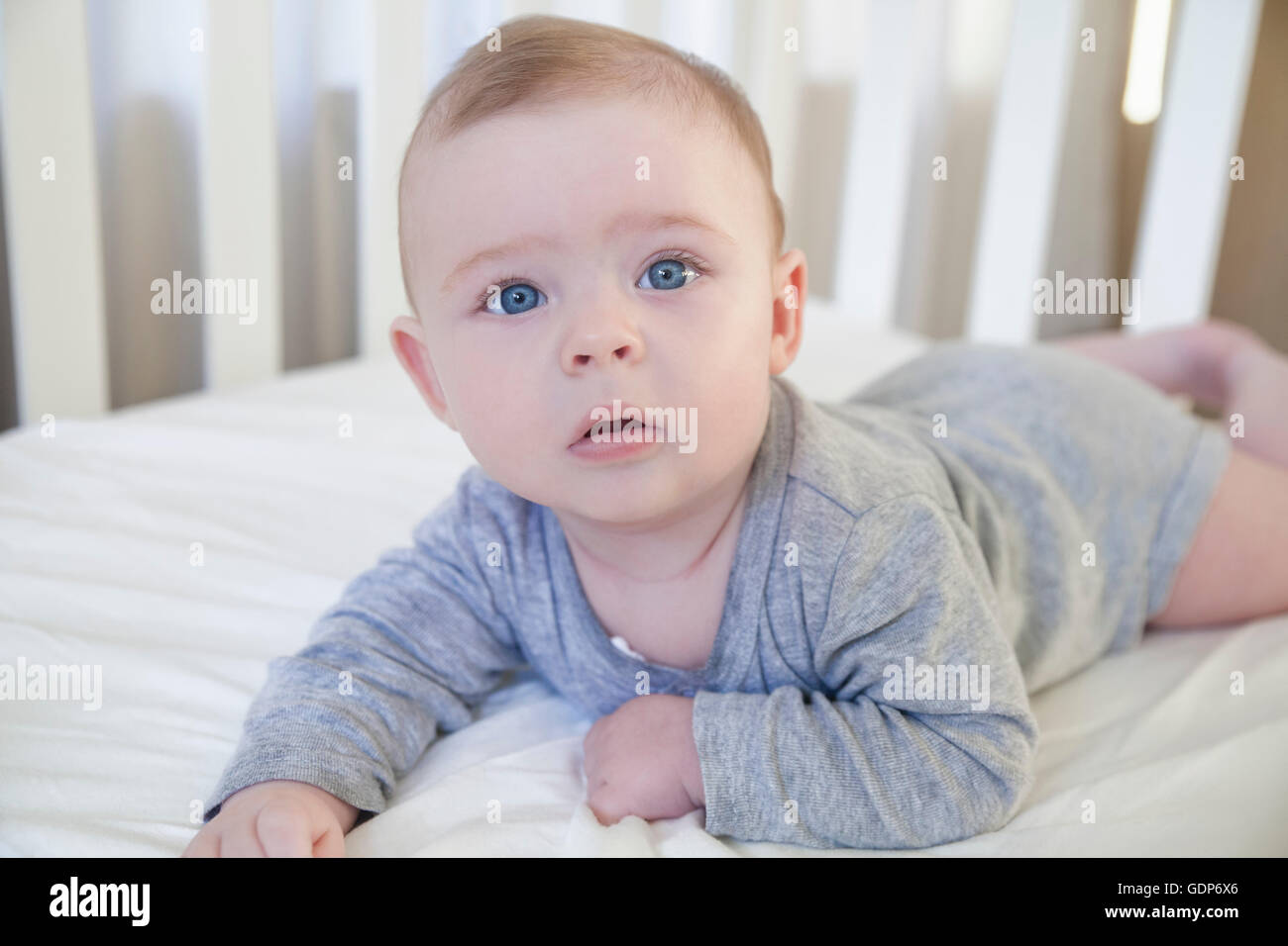 Baby boy waking up in his crib Stock Photo