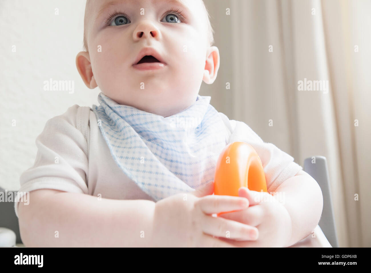 Baby boy in high chair with teething ring Stock Photo