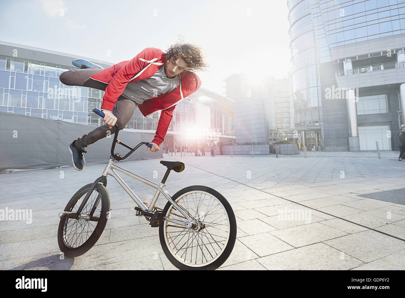 BMX Biker doing stunt in urban area Stock Photo