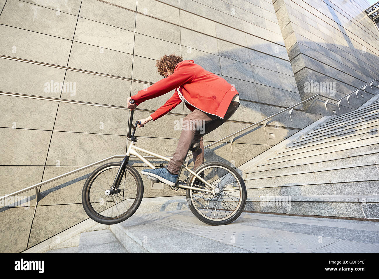 Man riding BMX by steps in urban area Stock Photo