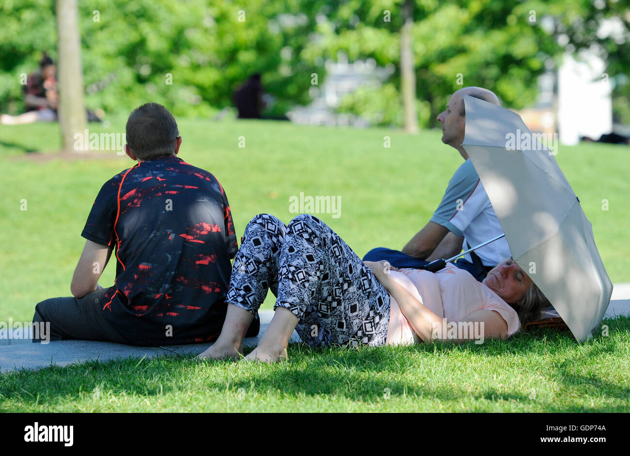 People enjoy the hot weather in Jubilee Gardens in London, as Britain has sweltered on the hottest day of the year so far, with soaring temperatures sparking a surge in calls for medical help and causing delays on the railway. Stock Photo