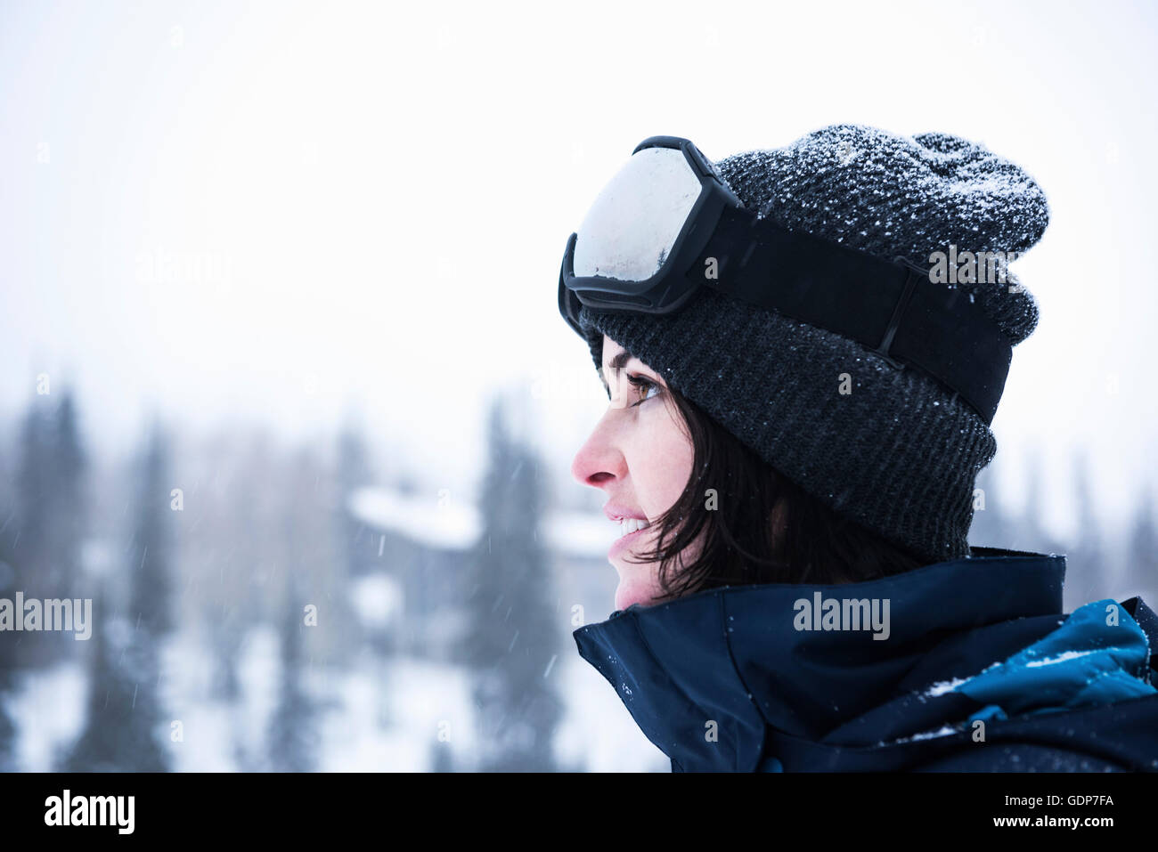 Portrait of young woman wearing ski goggles gazing at snow, Brighton Ski Resort outside of Salt Lake City, Utah, USA Stock Photo