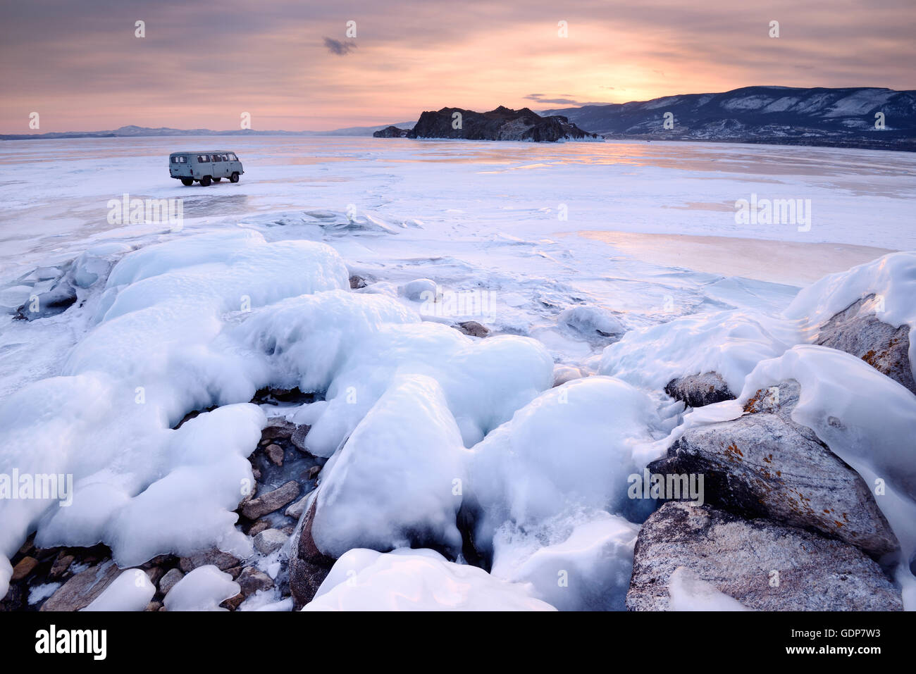 View of off road tourist vehicle and Oltrek Island at sunset, Baikal Lake, Olkhon Island, Siberia, Russia Stock Photo