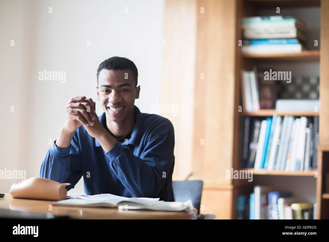 Portrait of happy young male high school student sitting at desk Stock ...