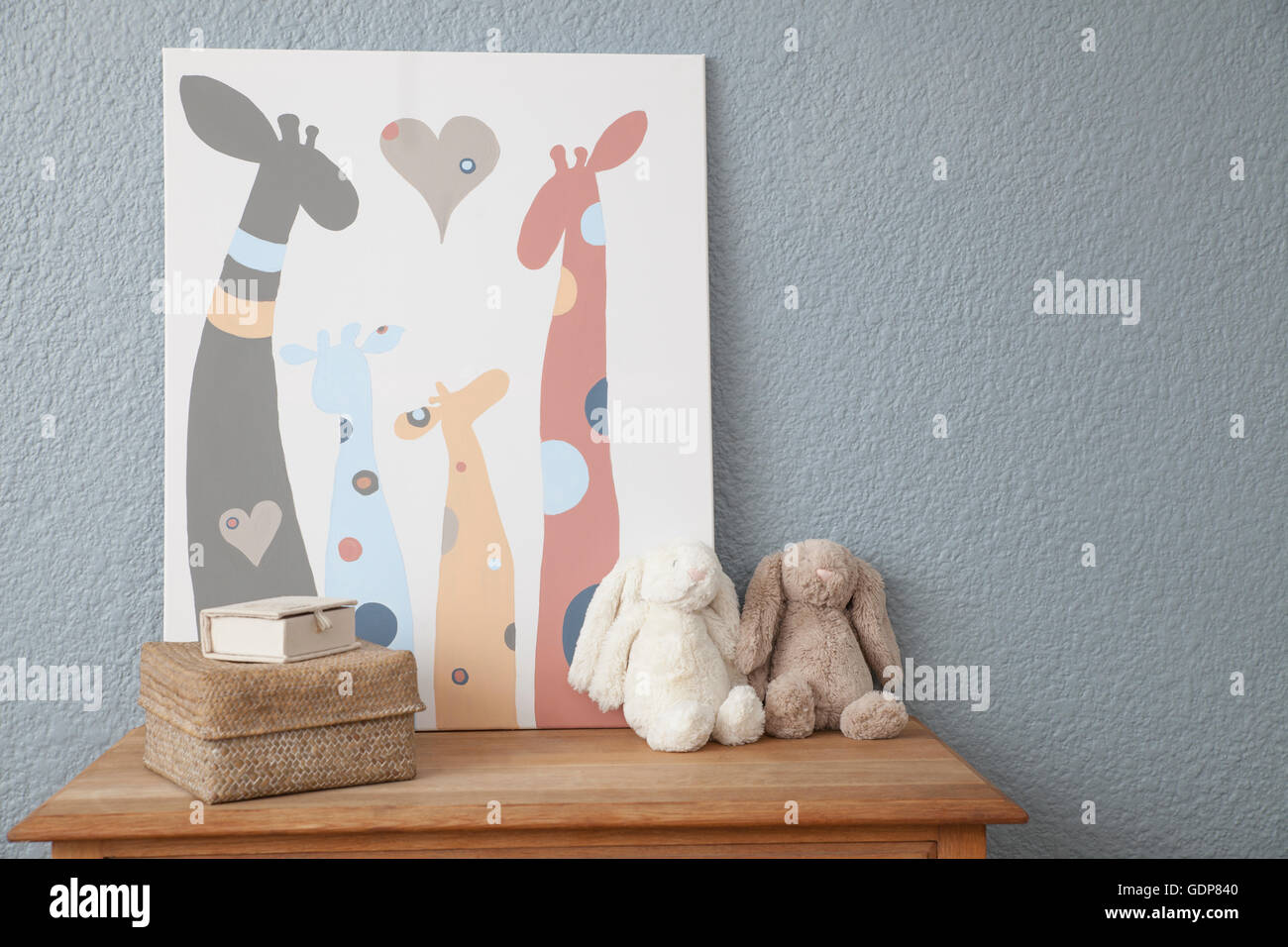 Picture and soft toys on chest of drawers in baby's nursery Stock Photo