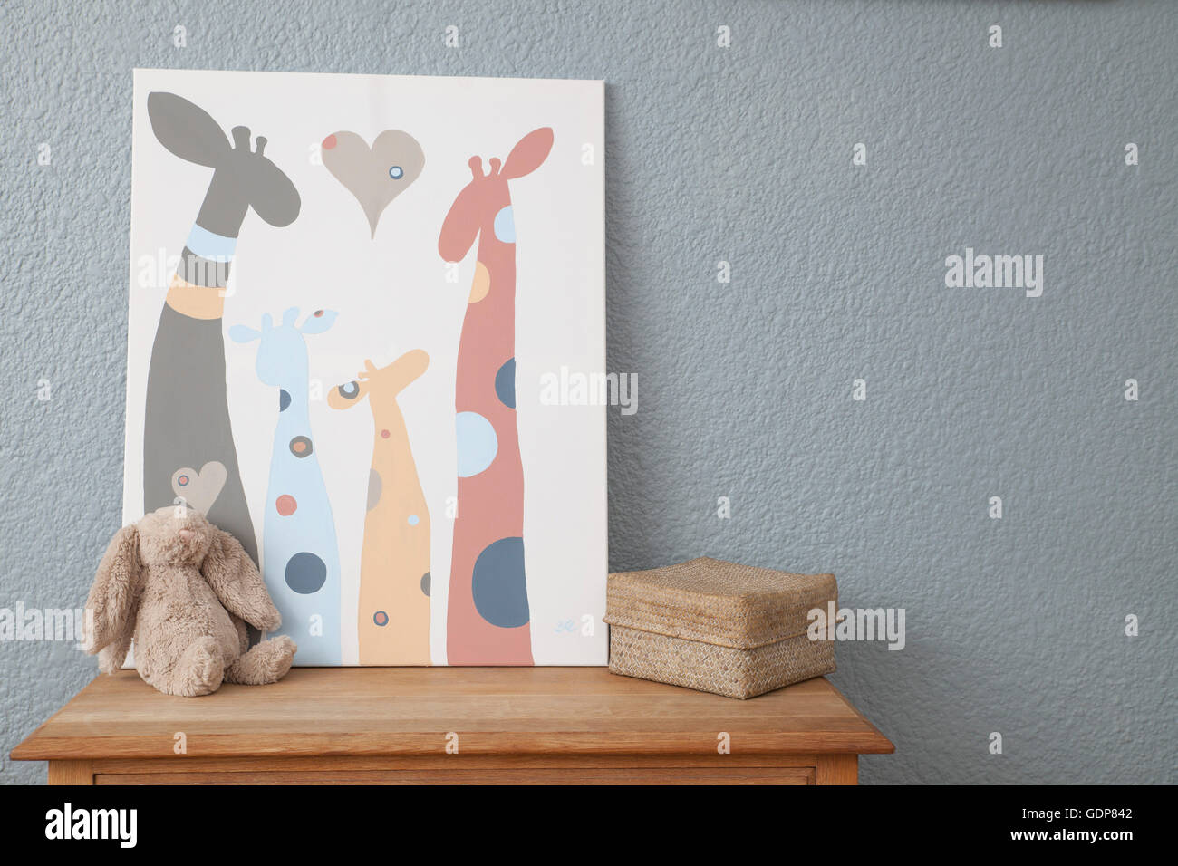 Picture and soft toy on chest of drawers in baby's nursery Stock Photo