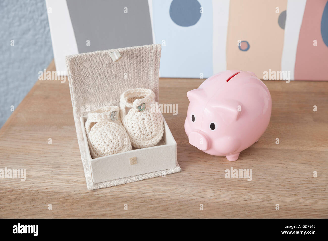 Baby shoes and piggy bank, close-up Stock Photo