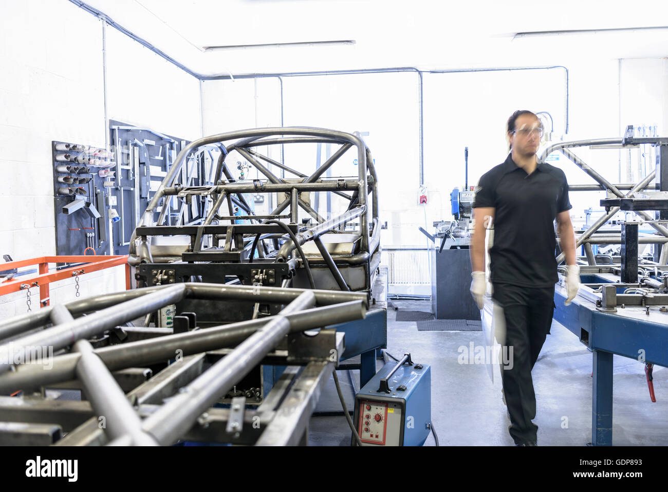 Engineer with racing car roll cages in racing car factory Stock Photo