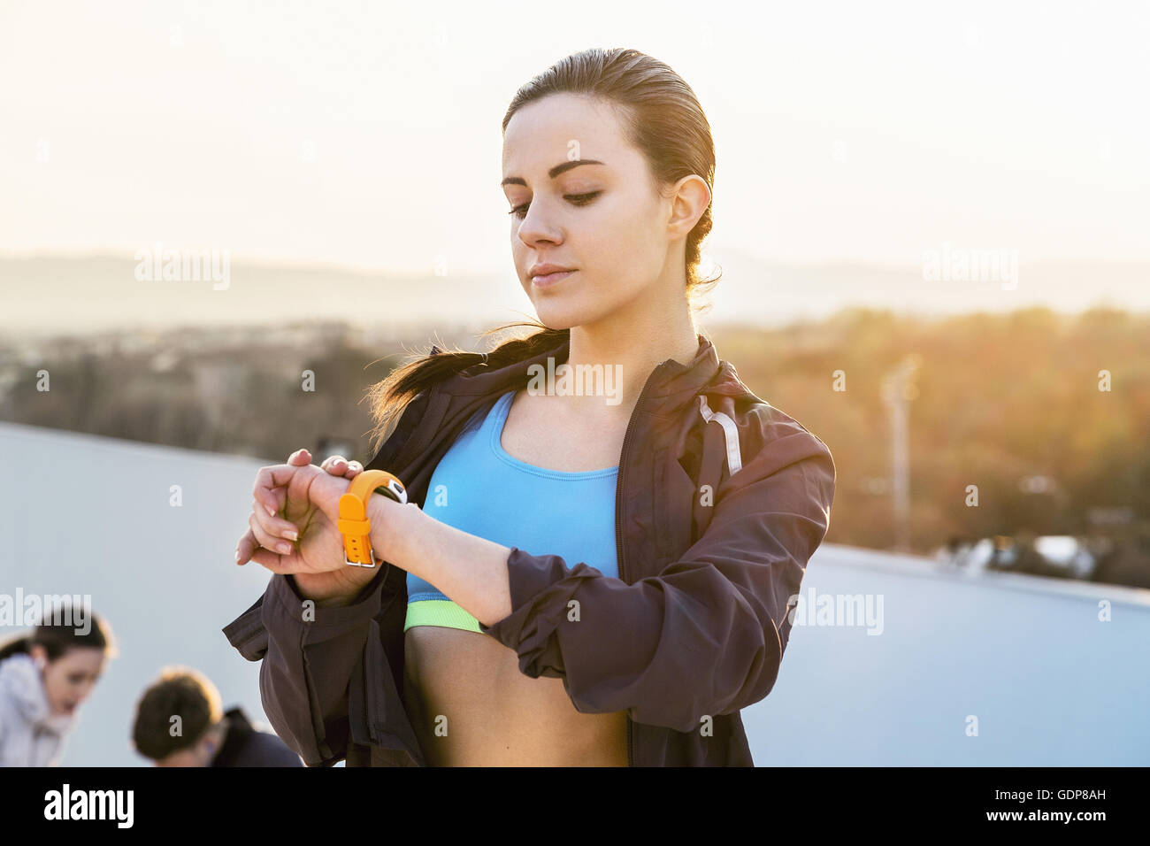 Young woman, outdoors, looking at activity tracker Stock Photo