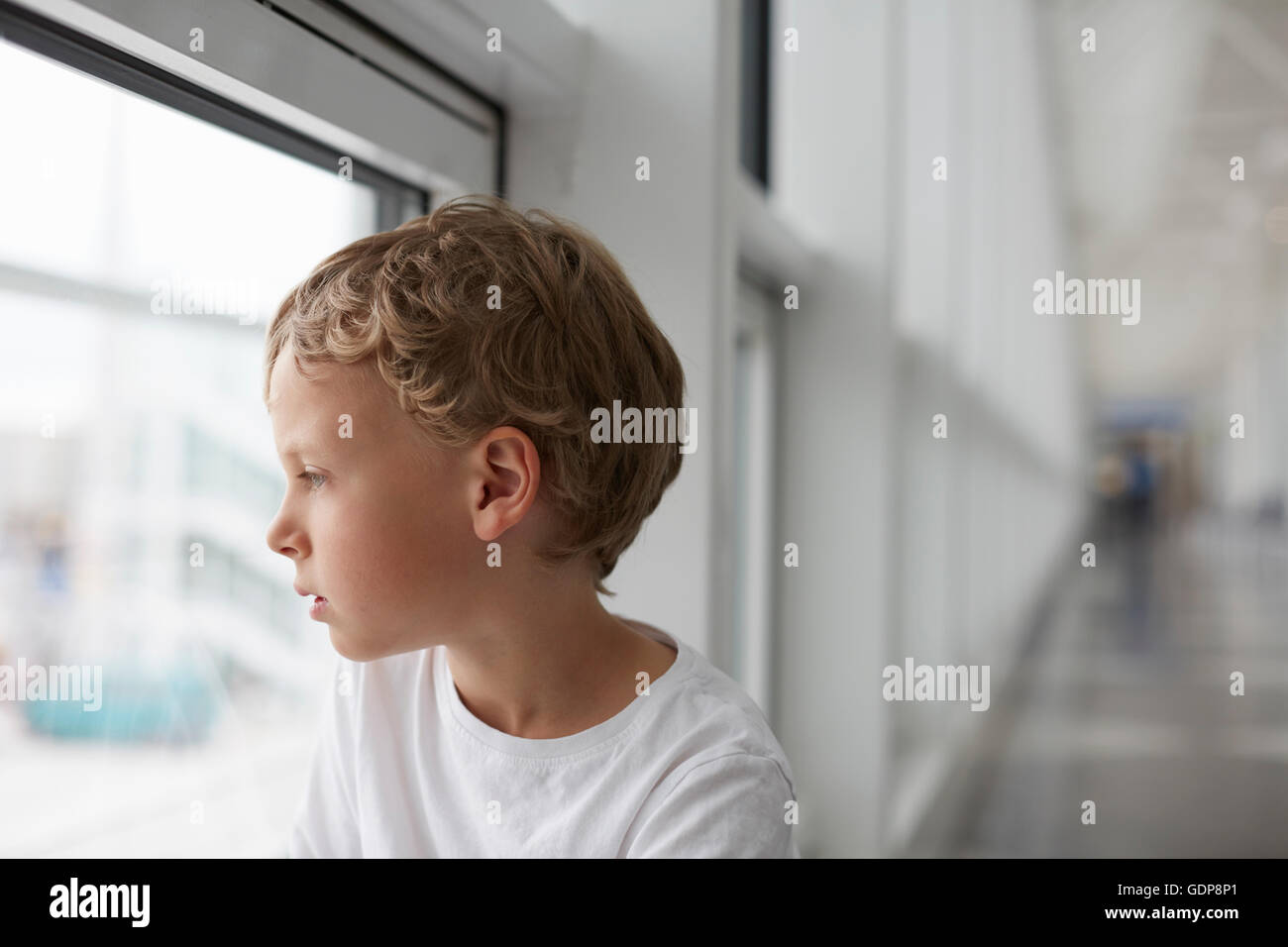 Boy looking out of airport window Stock Photo