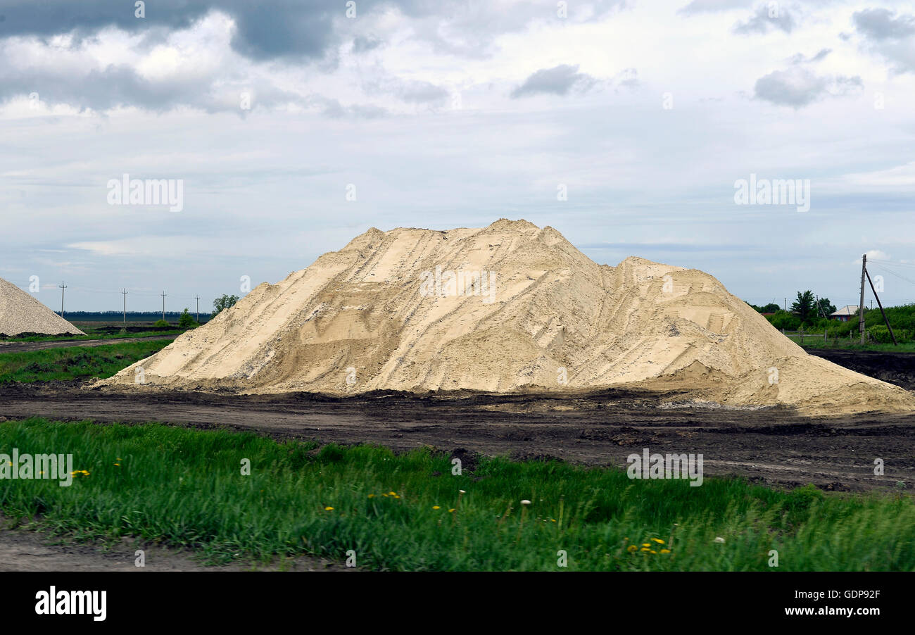 Yellow excavator working digging in sand quarry Stock Photo