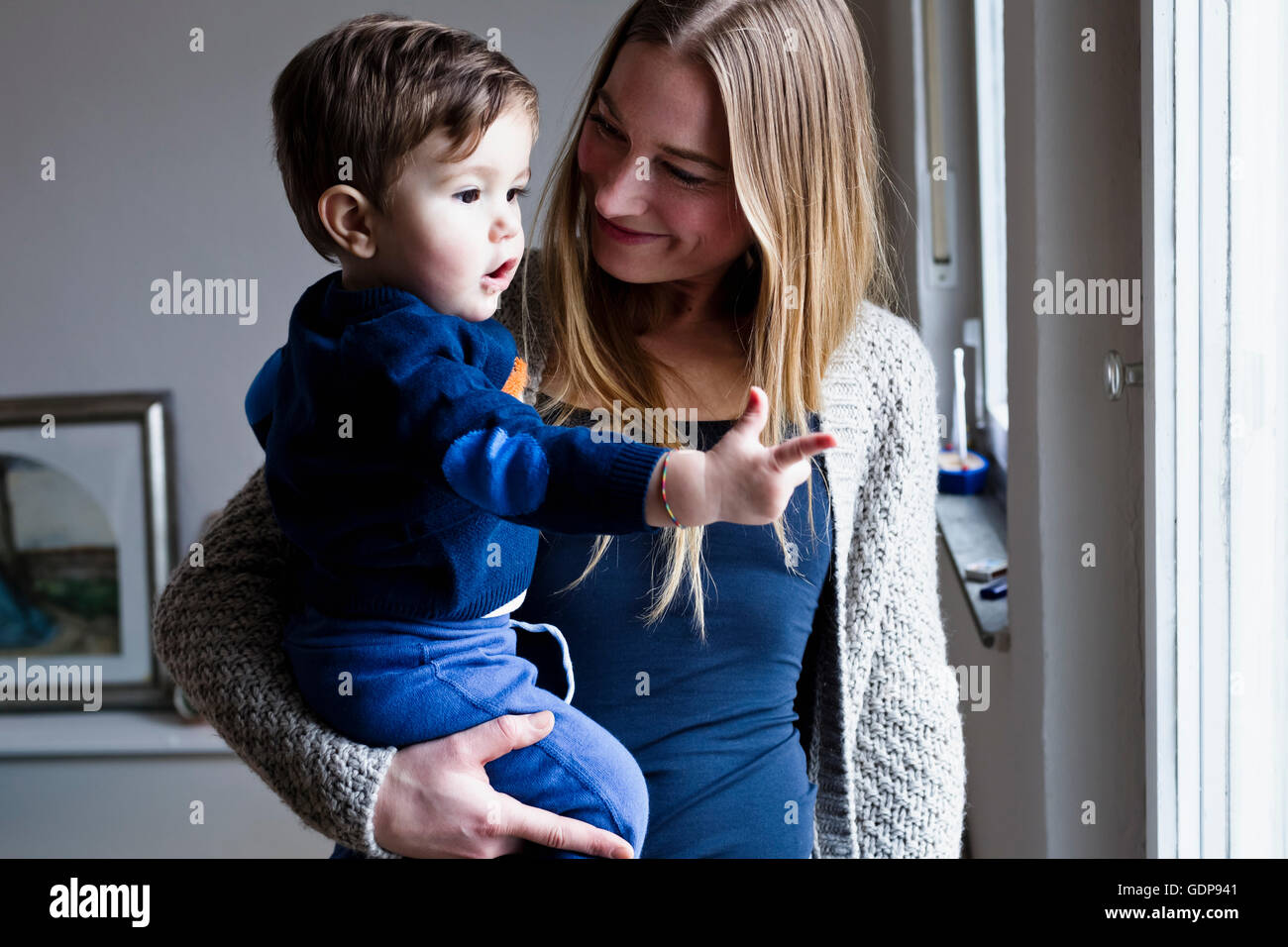 Mid adult woman carrying baby son, pointing Stock Photo