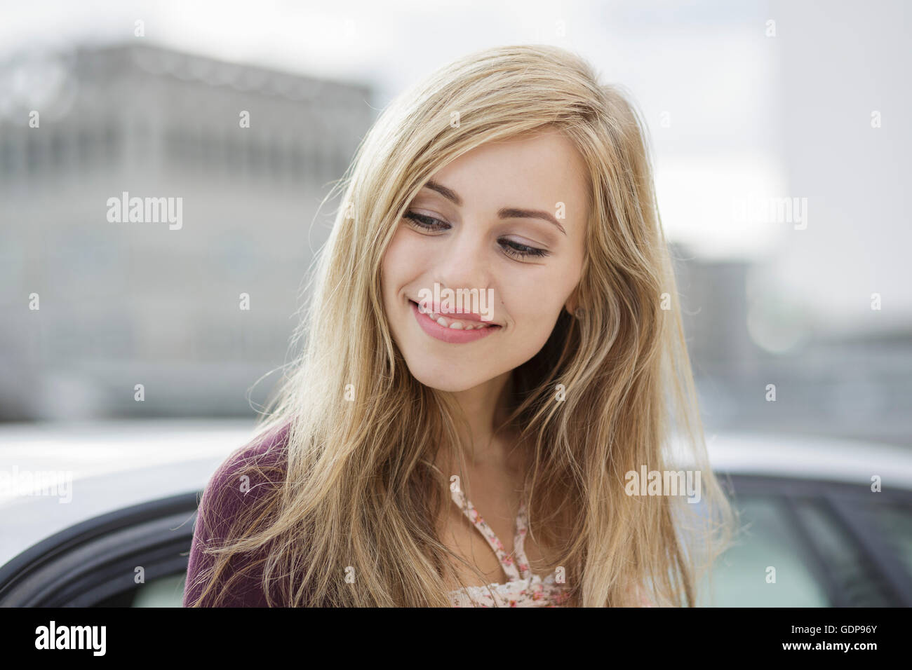 Beautiful long haired blond young woman in city Stock Photo
