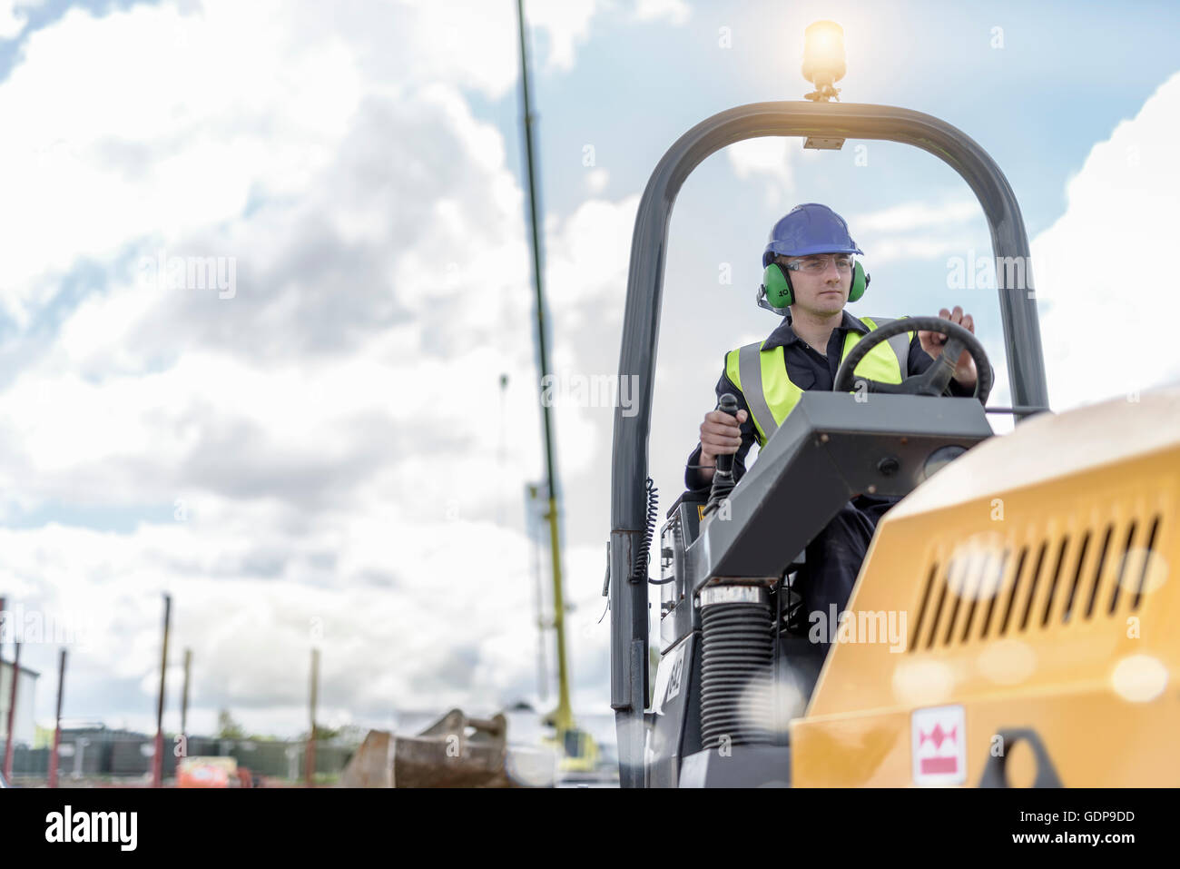 Apprentice builders training with road roller on building site Stock Photo