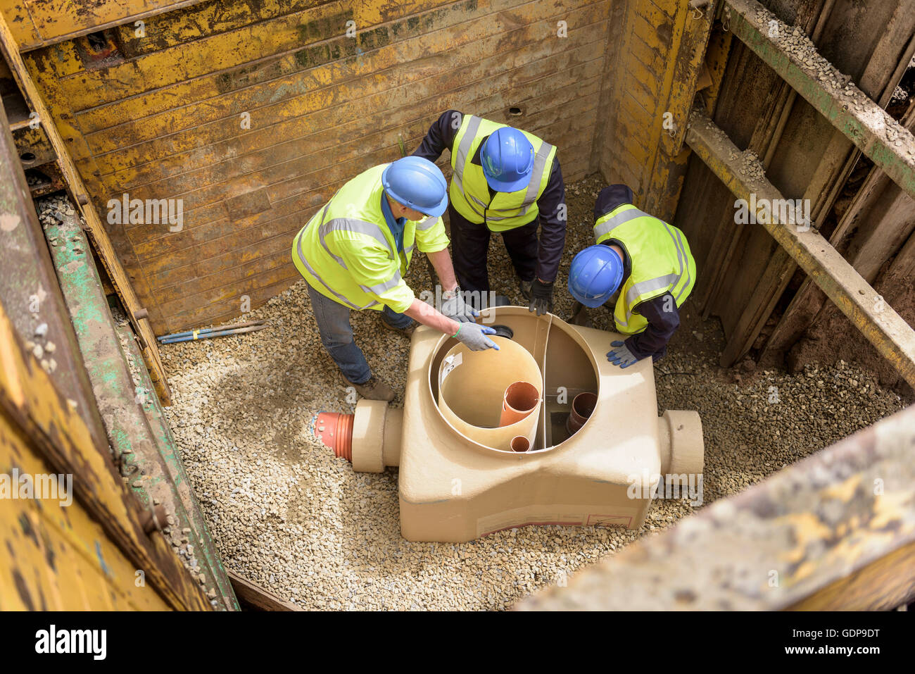 Apprentice builders training with drainage in hole on building site Stock Photo