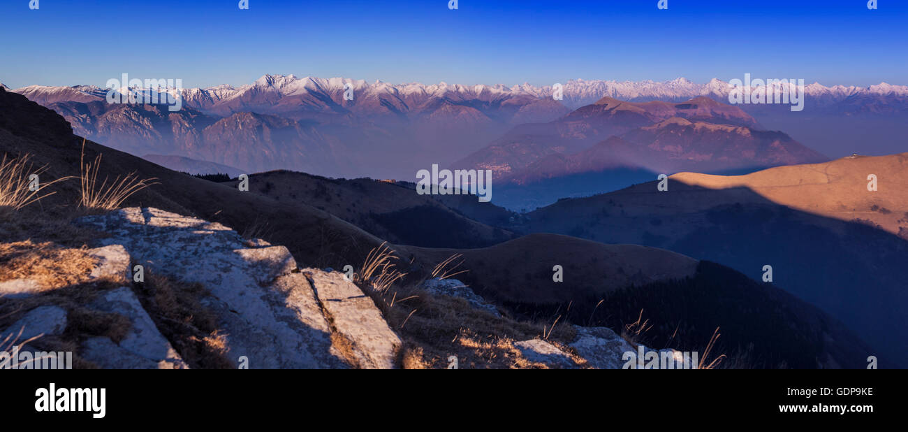 Elevated panoramic landscape with distant snow capped mountains, Monte Generoso,Ticino, Switzerland Stock Photo
