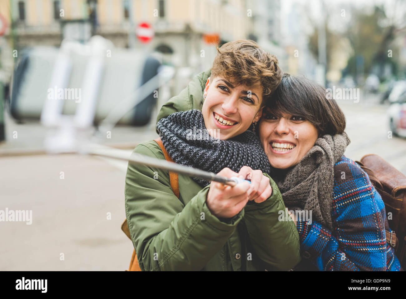 Two sisters, taking self portrait using selfie stick, outdoors Stock Photo