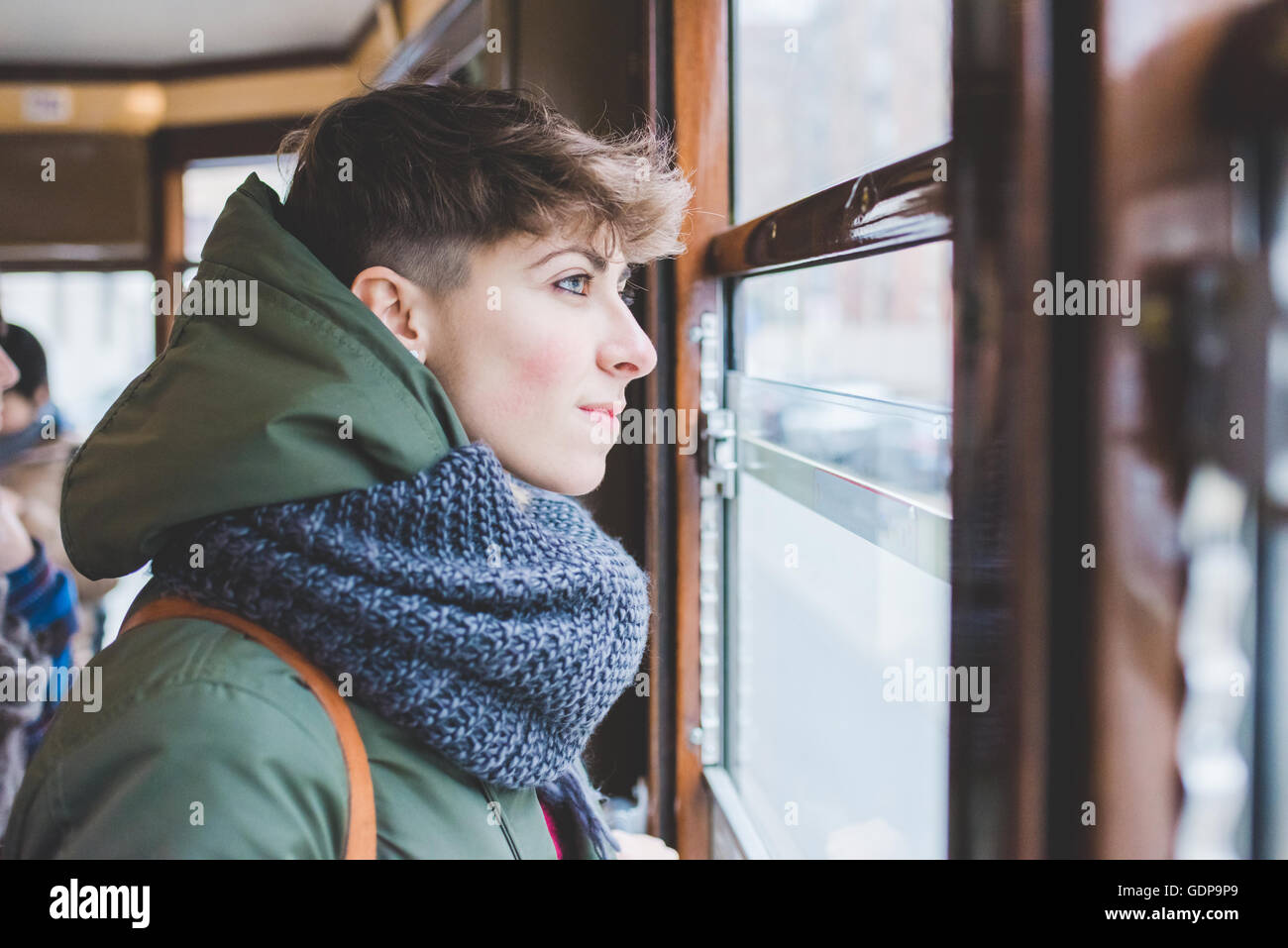 Young woman looking out of cable car window Stock Photo