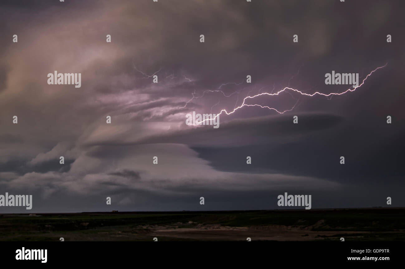Lightning shoots out of the updraft into the rain of the front flank downdraft of this supercell Stock Photo