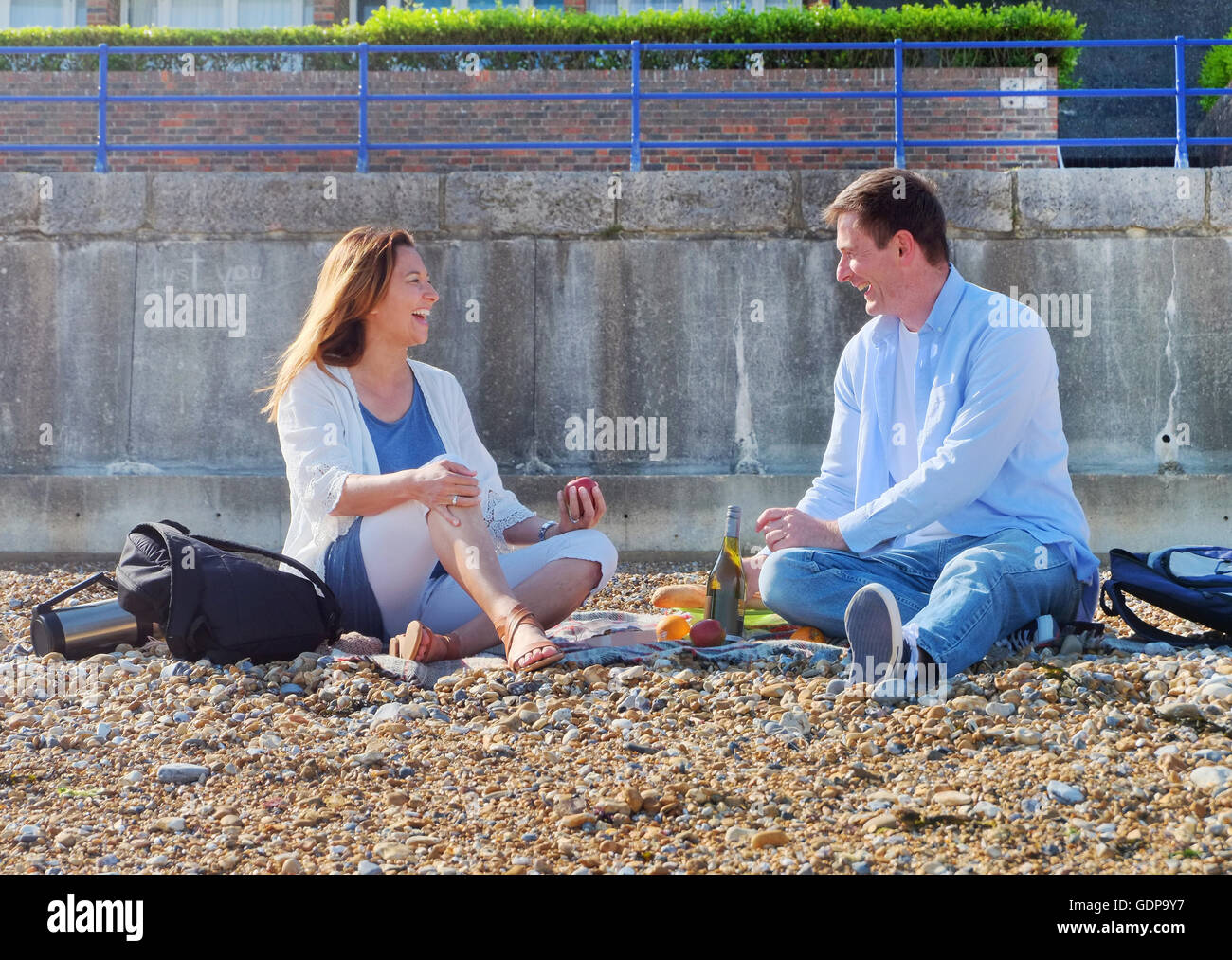 Couple having picnic on shingle beach Stock Photo