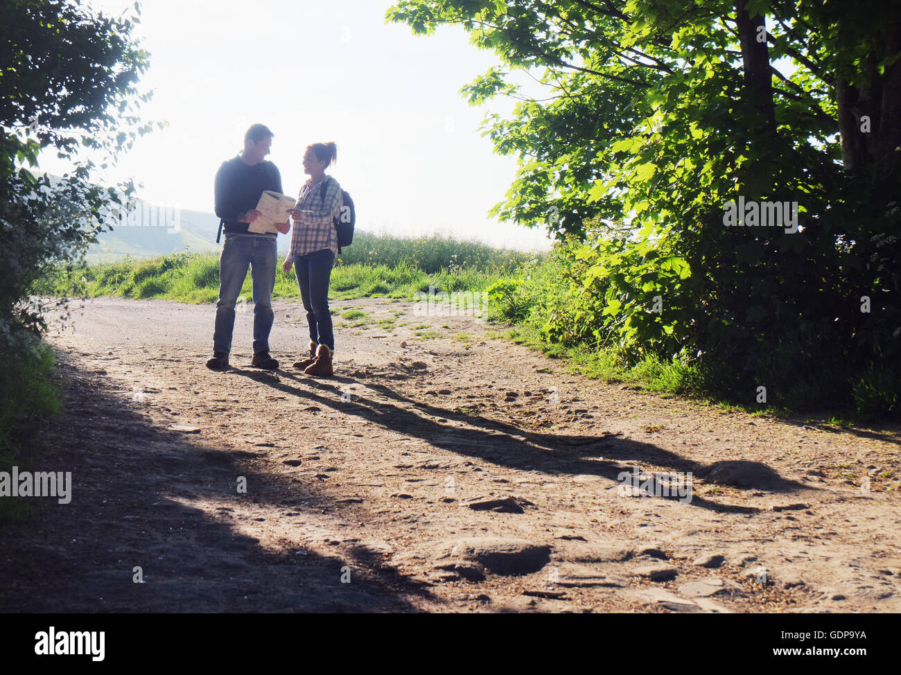 Couple hiking on dirt track reading map Stock Photo