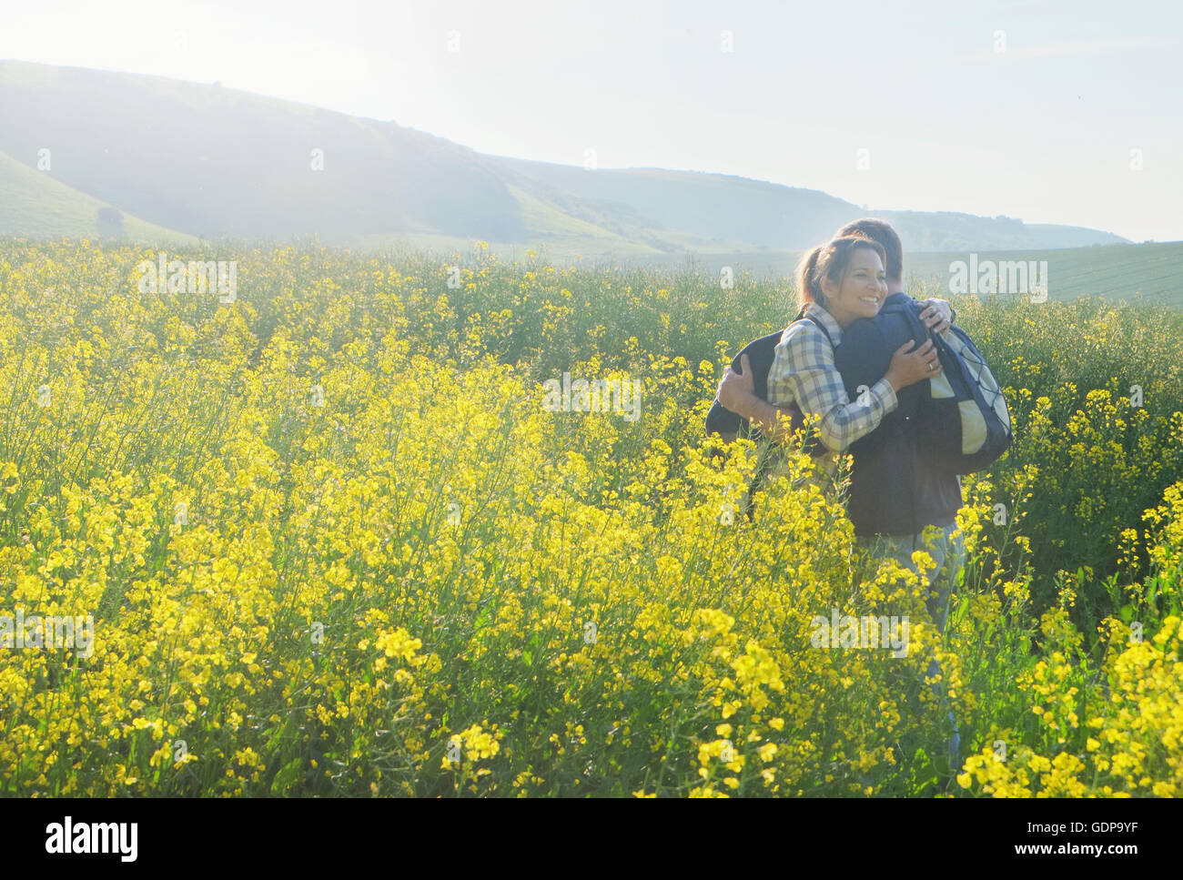 Couple in rapeseed field hugging Stock Photo