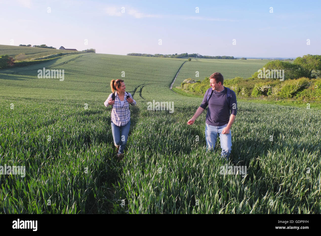 Couple hiking in field Stock Photo