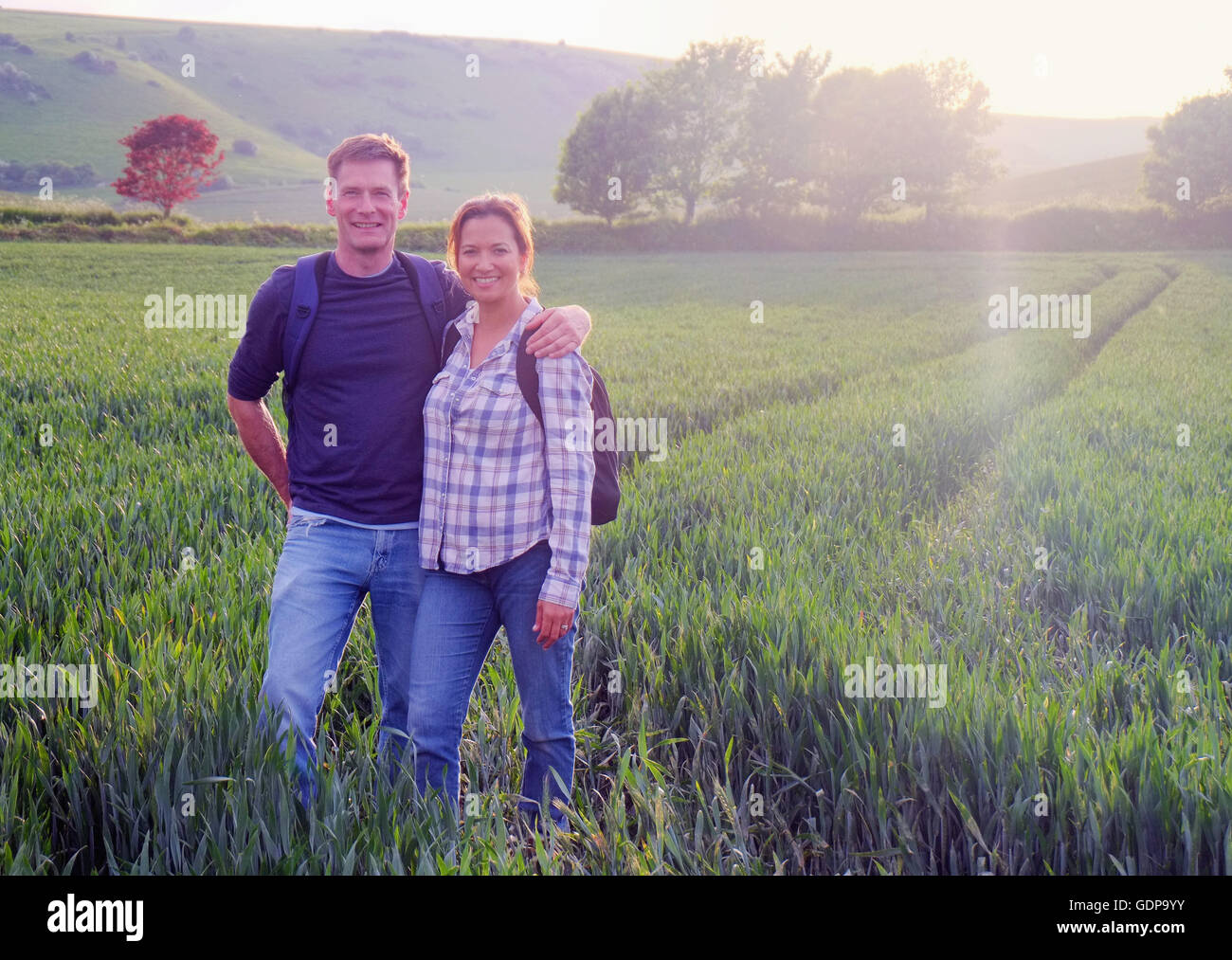 Couple in field looking at camera smiling Stock Photo