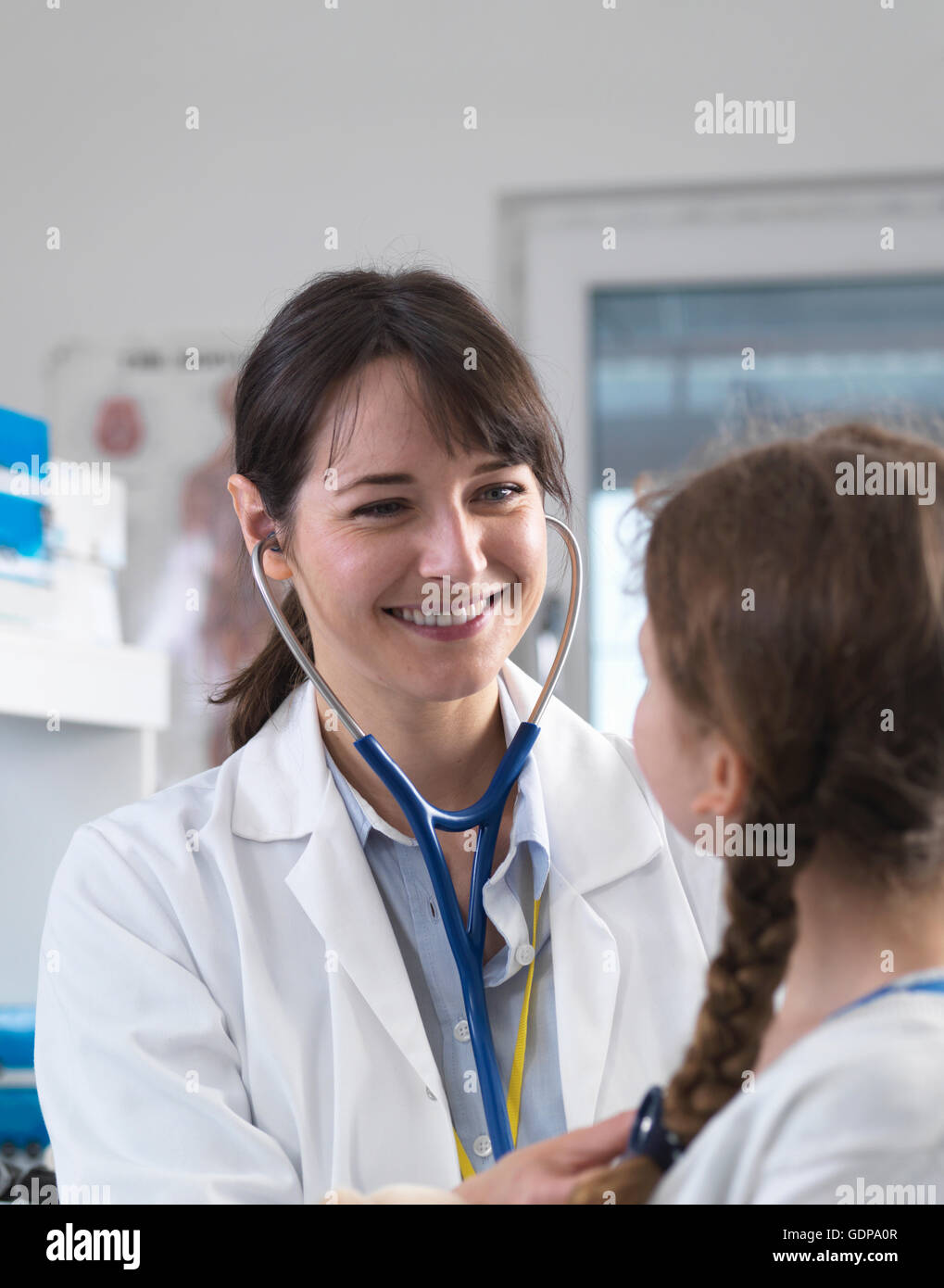 Female paediatric doctor listening to a young girl's chest with a