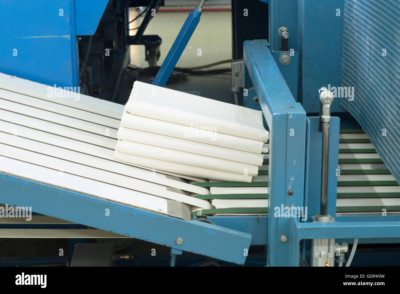 Laundry folded on ironing machine Stock Photo Alamy