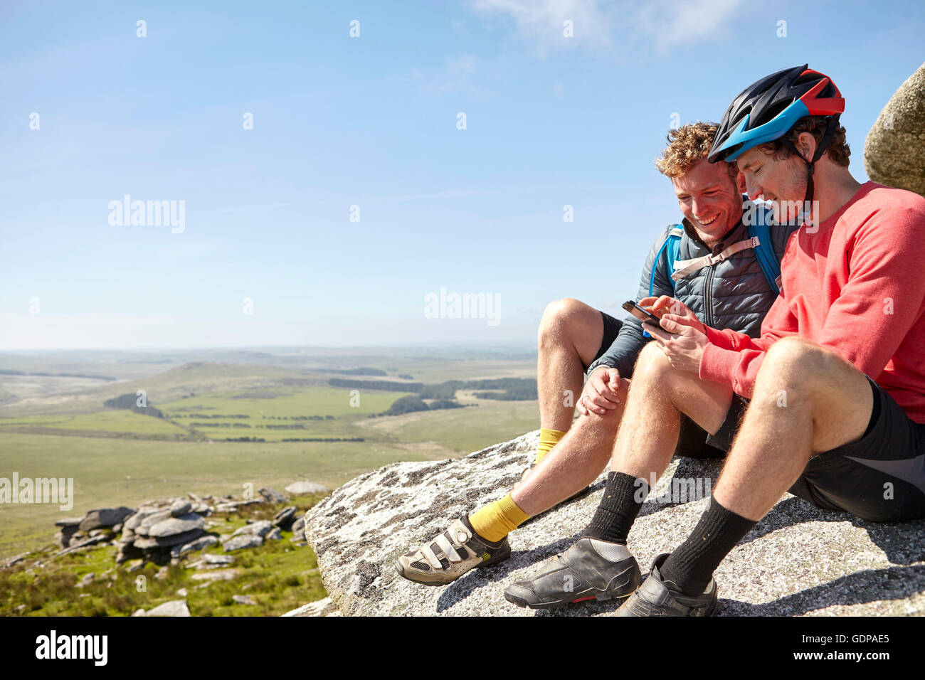 Cyclists resting on rocky outcrop Stock Photo