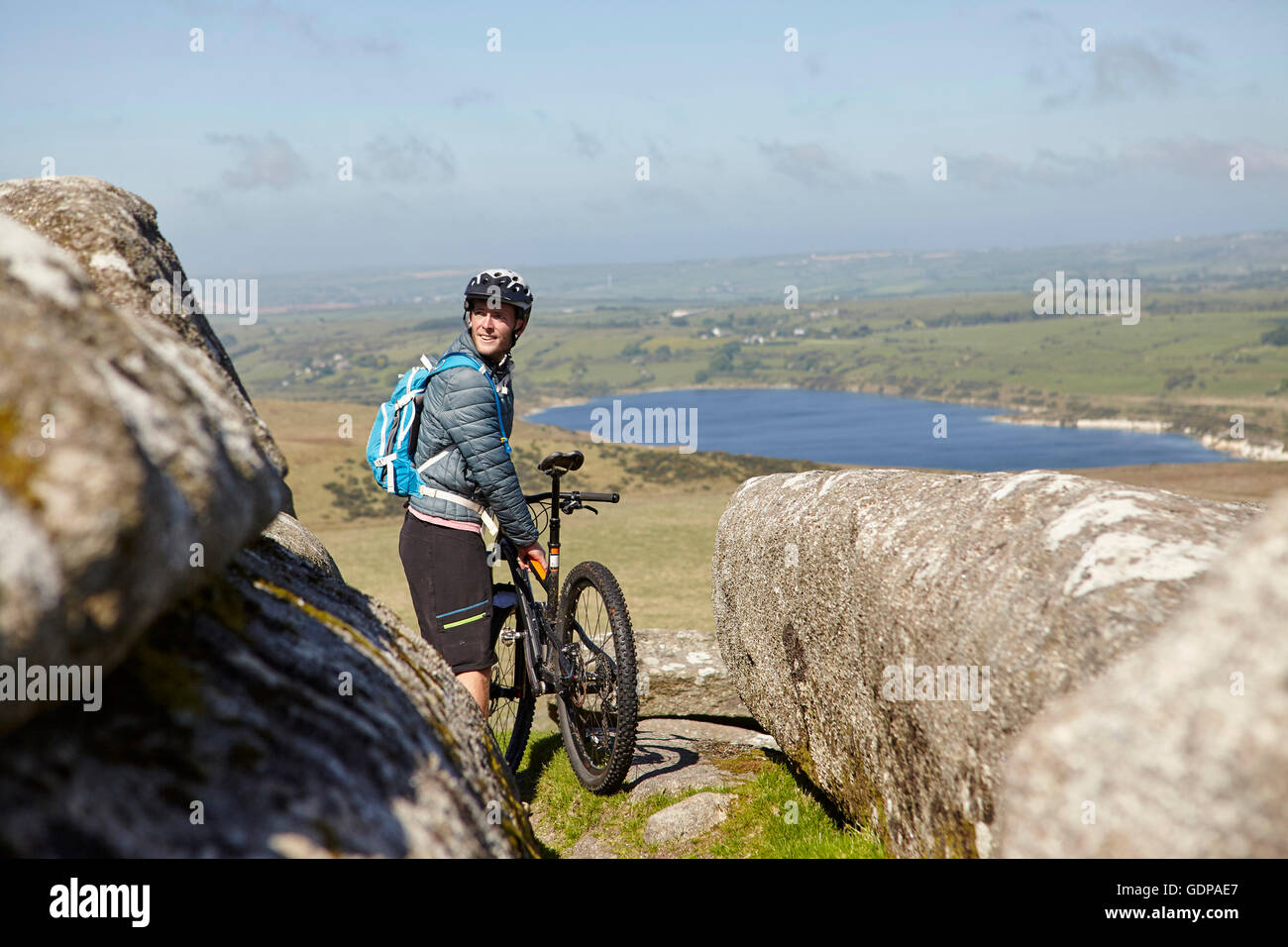 Cyclist with bicycle on rocky outcrop Stock Photo