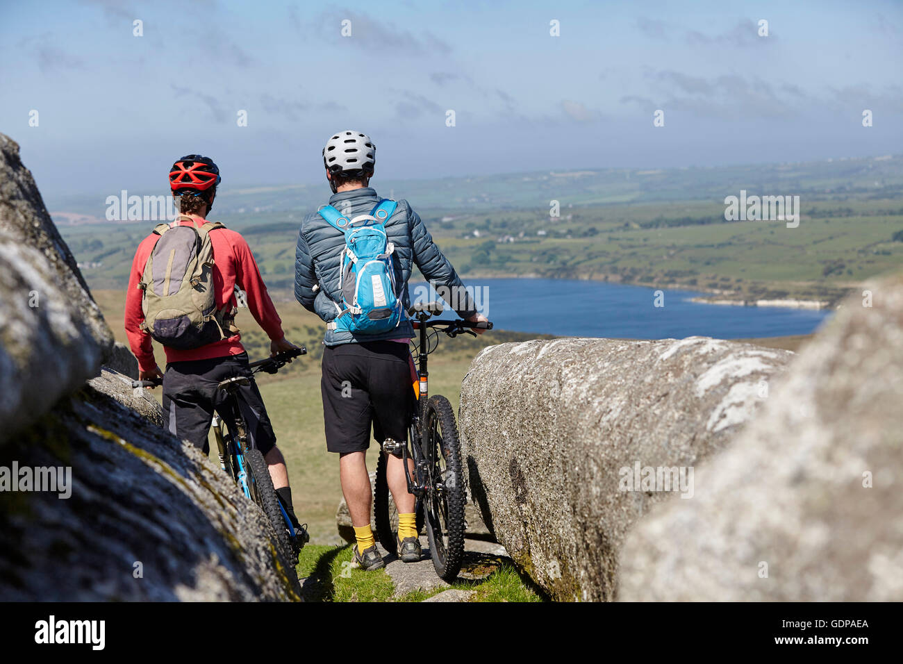 Cyclists with bicycles on rocky outcrop Stock Photo