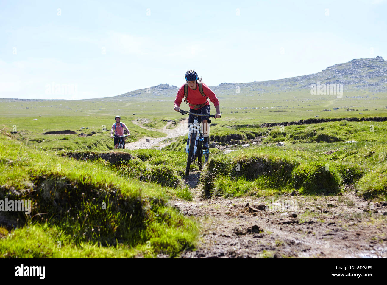 Cyclists cycling down hillside Stock Photo