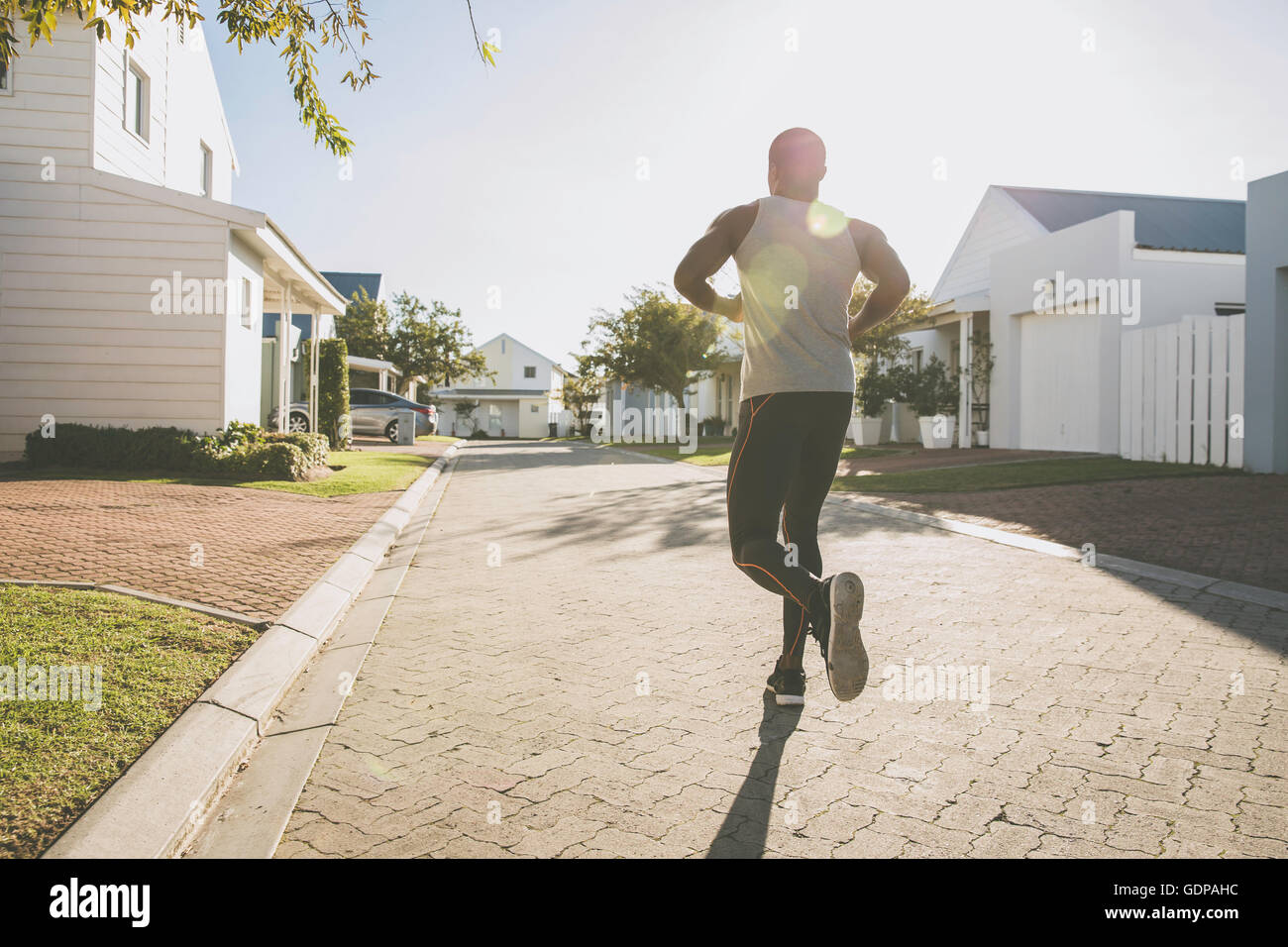 Rear view of man jogging in residential area Stock Photo Alamy