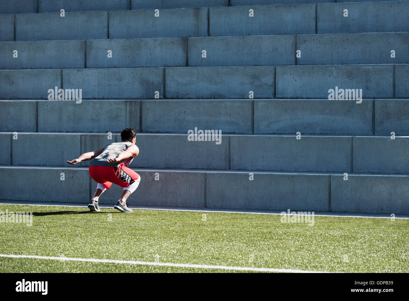 Young man training, preparing to jump up playing field stairway Stock Photo