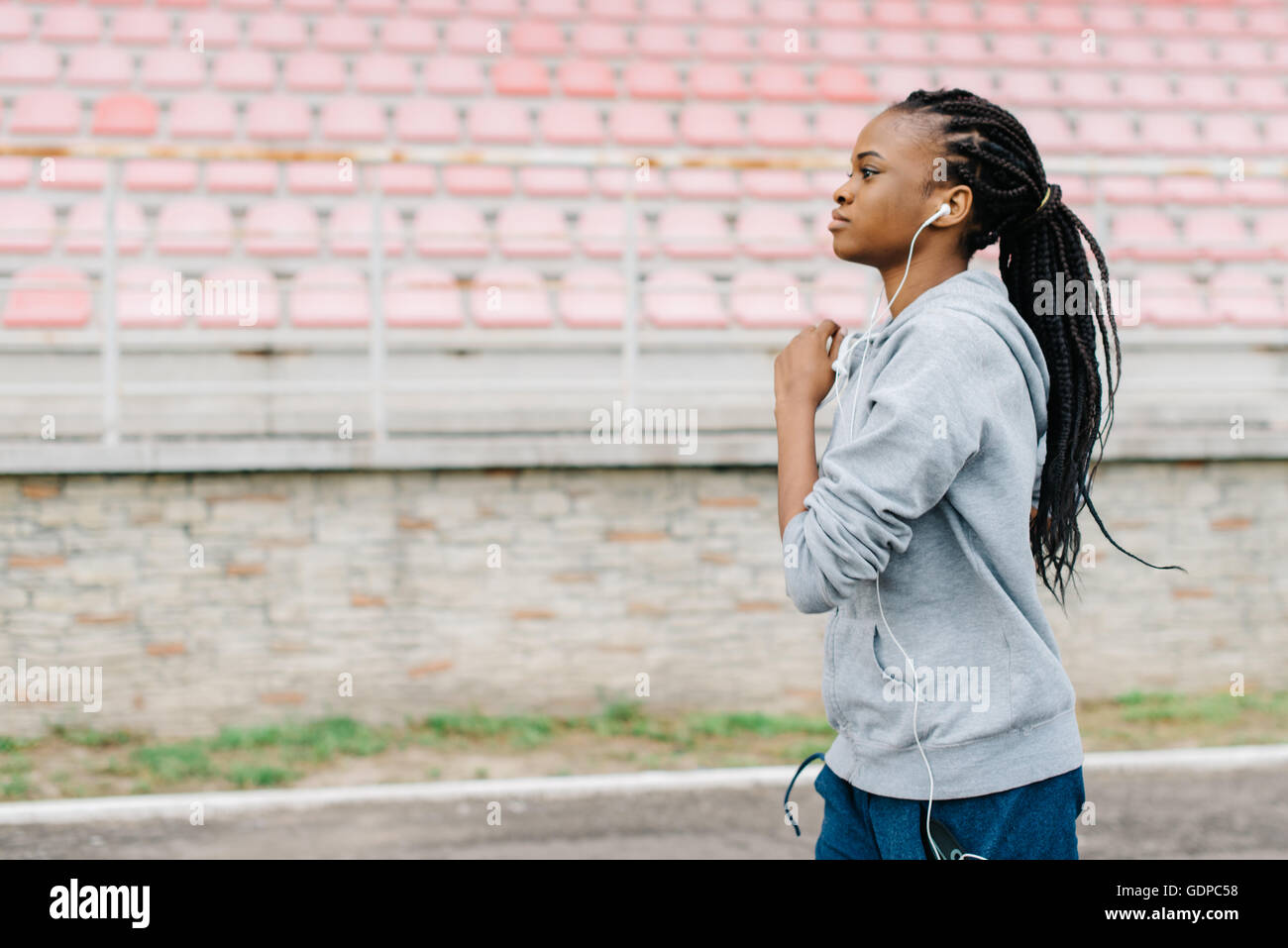Fitness, sport, training, people and lifestyle concept - african american woman running on track outdoors Stock Photo