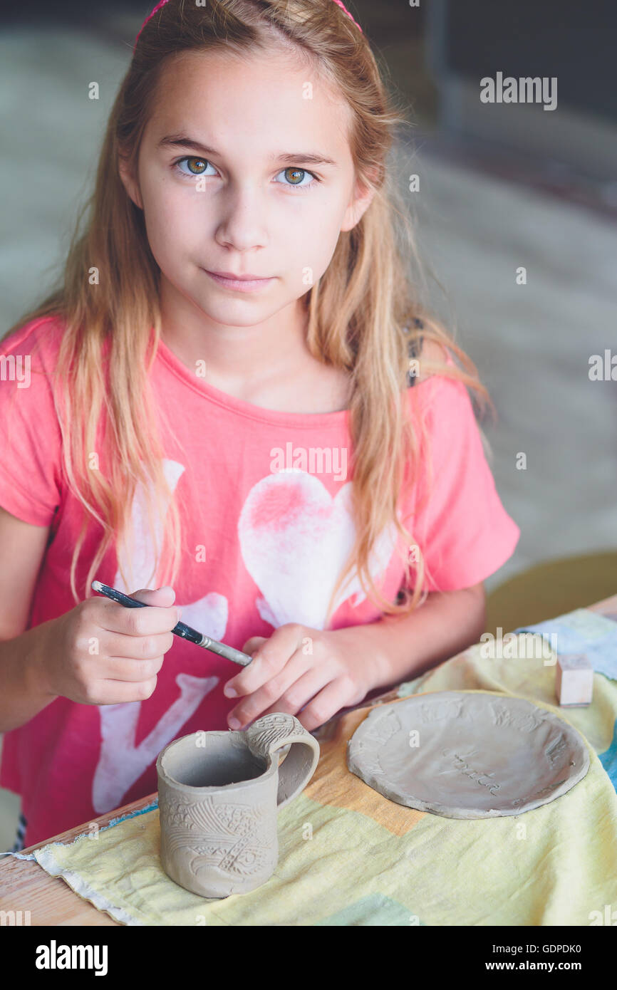 Girl making her first pottery in ceramic workshop Stock Photo