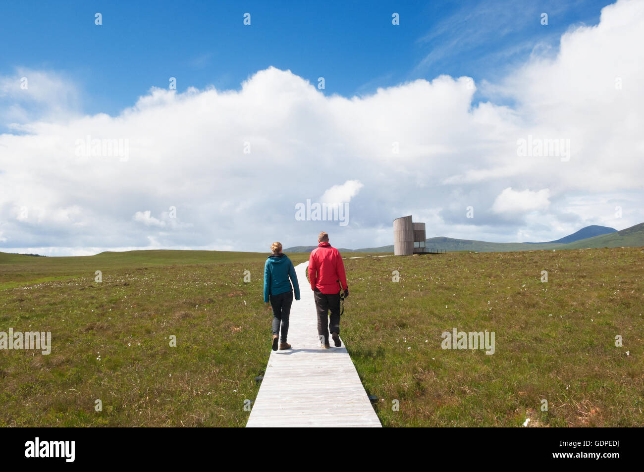 Visitors walking towards the viewing tower at Forsinard RSPB reserve - Sutherland, Scotland. Stock Photo
