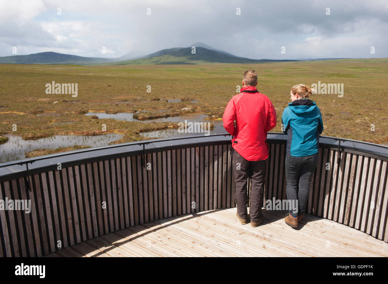 Young couple looking over peatland pools from the viewing tower on the RSPB Dubh Lochan Trail, Forsinard, Sutherland, Scotland. Stock Photo