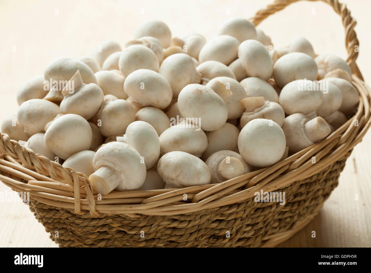 Basket with small white button mushrooms Stock Photo