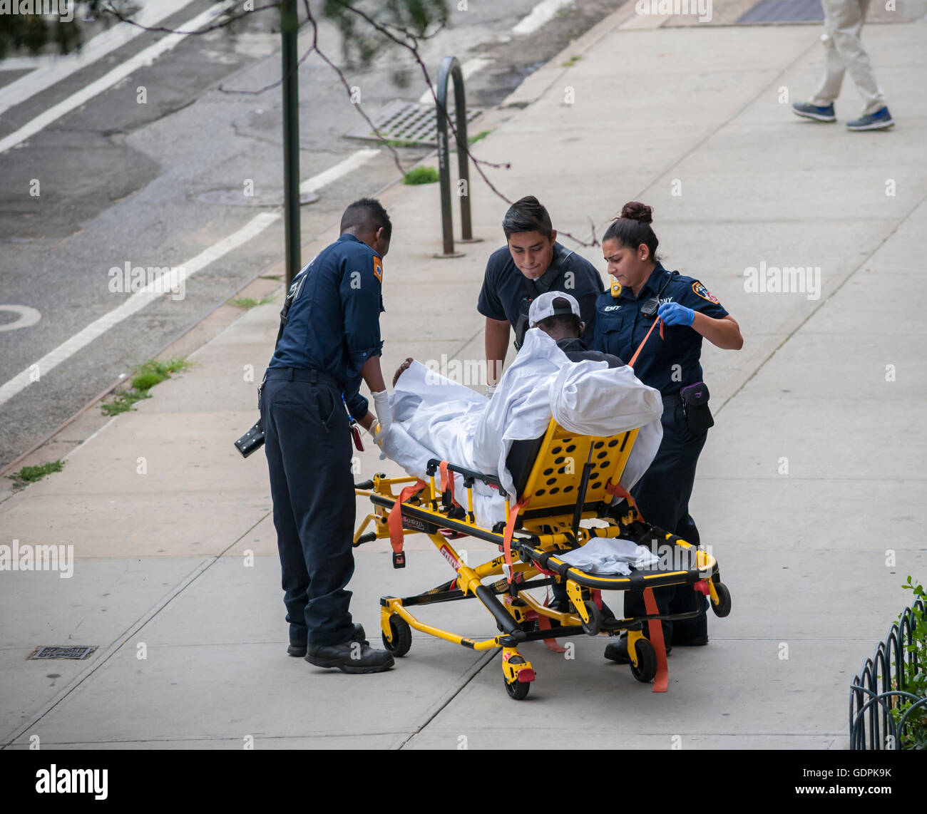 FDNY Emergency Service Technicians assist a homeless individual sleeping on the sidewalk in the Chelsea neighborhood of New York on Wednesday, July 3, 2016. (© Richard B. Levine) Stock Photo
