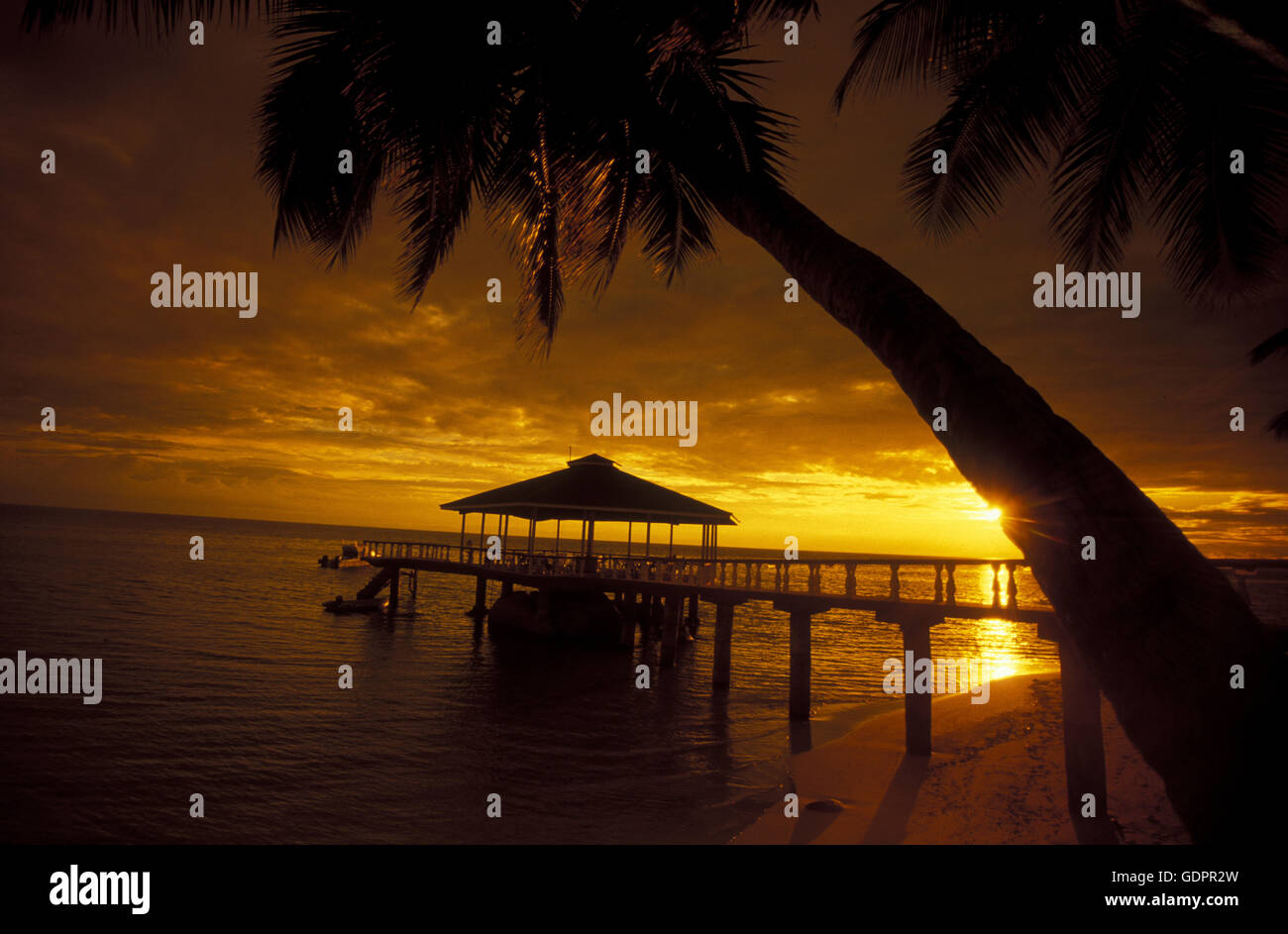 Ein Hotelstrand mit Pavillon bei Sonnenuntergang auf der Insel Praslin auf den Seychellen im Indischen Ozean. Stock Photo