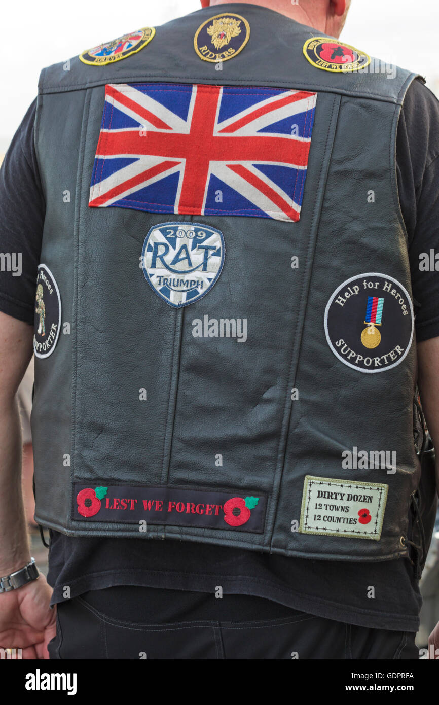 Help for Heroes supporter, Lest we forget badge and other badges on back of bikers leather jacket on bike night at Poole, Dorset UK  in July Stock Photo
